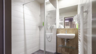 Sie sehen ein Badezimmer aus der Family Friends 4 Kategorie im JUFA Hotel Malbun. Der Ort für erholsamen Familienurlaub und einen unvergesslichen Winter- und Wanderurlaub.