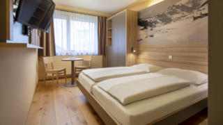 Sie sehen ein Doppelzimmer im JUFA Hotel Malbun. Der Ort für erholsamen Familienurlaub und einen unvergesslichen Winter- und Wanderurlaub.