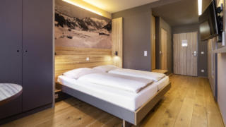 Sie sehen ein Doppelzimmer im JUFA Hotel Malbun. Der Ort für erholsamen Familienurlaub und einen unvergesslichen Winter- und Wanderurlaub.