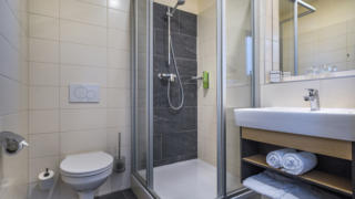 Sie sehen ein Badezimmer aus der Doppelzimmer Superior Kategorie im JUFA Hotel Schladming. Der Ort für erholsamen Ski- und Wanderurlaub für Familien.