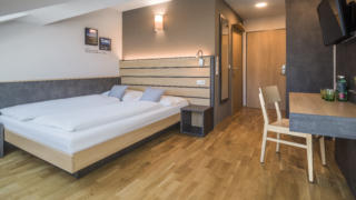 Sie sehen ein Einzelzimmer im JUFA Hotel Schladming. Der Ort für erholsamen Ski- und Wanderurlaub für Familien.