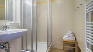 Sie sehen ein Badezimmer aus der Kategorie FF3 im JUFA Hotel Schladming. Der Ort für erholsamen Ski- und Wanderurlaub für Familien.
