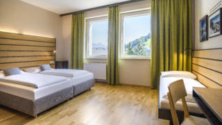 Sie sehen ein Zimmer aus der Kategorie FF3 Plus im JUFA Hotel Schladming. Der Ort für erholsamen Ski- und Wanderurlaub für Familien.