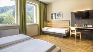 Sie sehen ein Zimmer aus der Kategorie FF3 Plus im JUFA Hotel Schladming. Der Ort für erholsamen Ski- und Wanderurlaub für Familien.