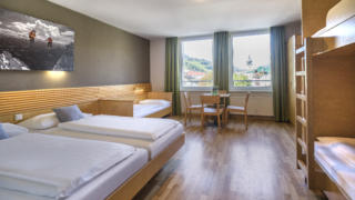 Sie sehen ein Zimmer aus der Kategorie FF5 im JUFA Hotel Schladming. Der Ort für erholsamen Ski- und Wanderurlaub für Familien.