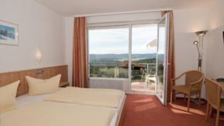 Sie sehen ein Doppelzimmer mit Ausblick im JUFA Hotel Schwarzwald. Das JUFA Hotel Schwarzwald ist idealer Ausgangspunkt für Ihren aktiven Urlaub im Hochschwarzwald.