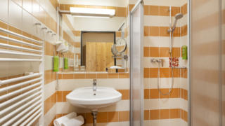 Sie sehen das Badezimmer aus der Family Friends 4 Zimmerkategorie im JUFA Klosterhotel Judenburg. Der Ort für erholsamen Familienurlaub und einen unvergesslichen Winter- und Wanderurlaub.