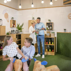 Sie sehen Kinder und Eltern in der Spielecke im JUFA Hotel Weiz. Der Ort für kinderfreundlichen und erlebnisreichen Urlaub für die ganze Familie.