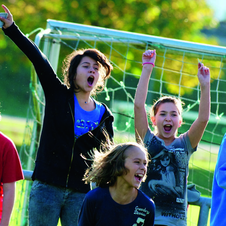 Kinder jubeln vor Fußballtor im Freien. JUFA Hotels bietet erlebnisreiche Feriencamps in den Bereichen Sport, Gesundheit, Bildung und Sprachen.