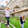 Sie sehen Kinder beim Spielen auf dem Spielplatz des JUFA Hotel Kronach – Festung Rosenberg***. Der Ort für kinderfreundlichen und erlebnisreichen Urlaub für die ganze Familie.
