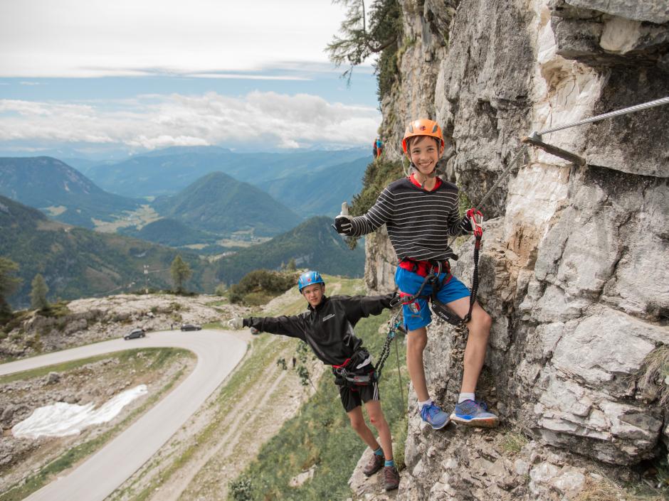 Zwei Jungs klettern am Klettersteig Sophie am Loser in Altaussee. JUFA Hotels bietet Ihnen den Ort für erlebnisreichen Natururlaub für die ganze Familie.
