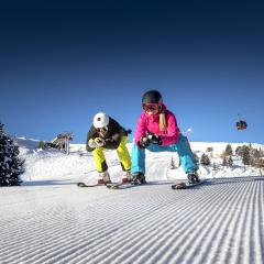 Sie sehen zwei Personen auf einer Abfahrt beim Skifahren am Kreischberg in der Region Murau.
