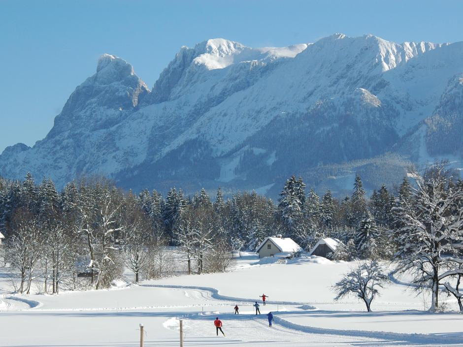 Wintersportler beim klassischen Langlaufen und sportlichen Skating in der Langlaufregion im Nationalpark Gesäuse in der Steiermark. JUFA Hotels bietet erholsamen Familienurlaub und einen unvergesslichen Winterurlaub.