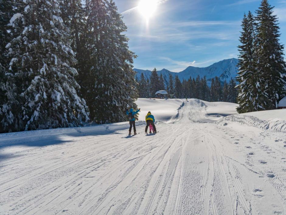 Sie sehen eine Famlie beim Skifahren in Laterns. Die JUFA Hotels bieten erholsamen Urlaub für die ganze Familie.