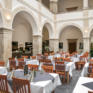 Sie sehen gedeckte Tische in der Lobby des JUFA Hotel Schloss Röthelstein/Admont***. Der Ort für märchenhafte Hochzeiten und erfolgreiche und kreative Seminare.