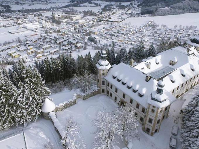 Sie sehen das JUFA Hotel Schloss Röthelstein/Admont*** mit Winterlandschaft in einer Luftaufnahme. JUFA Hotels bietet erholsamen Familienurlaub und einen unvergesslichen Winter- und Wanderurlaub.