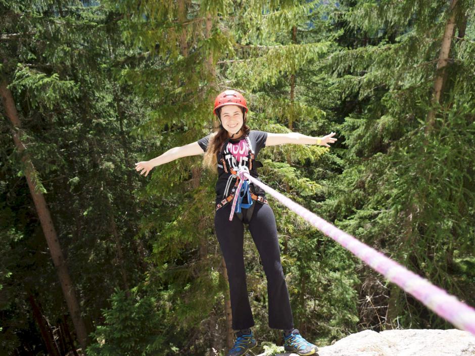 Sie sehen ein Mädchen beim Klettern auf einer Kletterwand im Lungau im Sommer. JUFA Hotels bietet erlebnisreiche Feriencamps in den Bereichen Sport, Gesundheit, Bildung und Sprachen.
