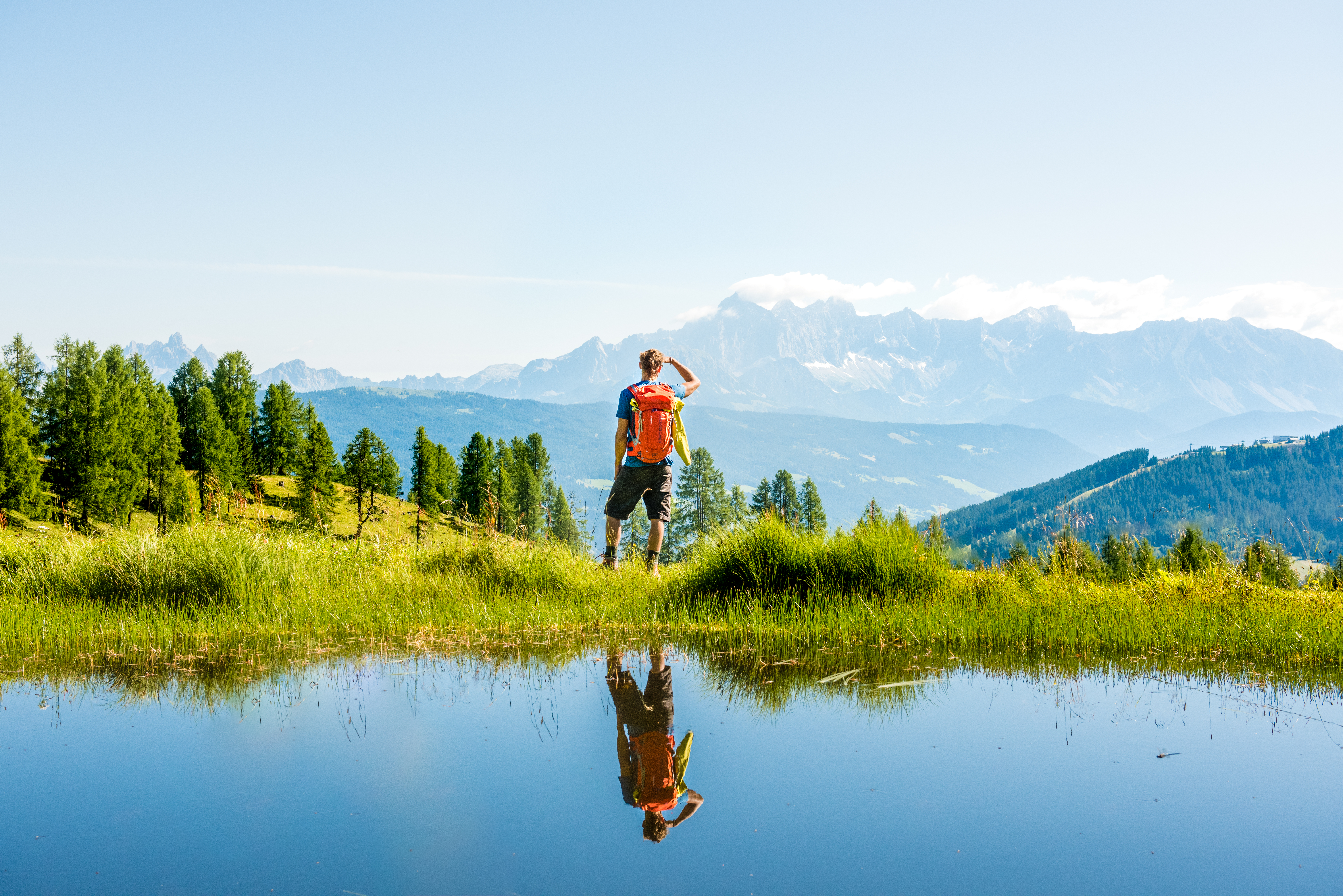 Sie sehen einen Mann beim Wandern im Salzburger Land mit herrlichem Bergpanorama. JUFA Hotels bietet erholsamen Familienurlaub und einen unvergesslichen Winter- und Wanderurlaub.