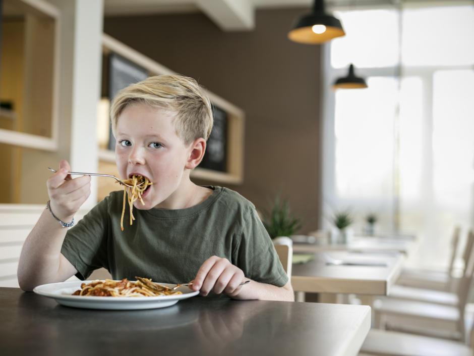 Sie sehen ein Kind beim Essen von Spaghettinudeln im JUFA Hotel Graz City***. Der Ort für erlebnisreichen Städtetrip für die ganze Familie und der ideale Platz für Ihr Seminar.