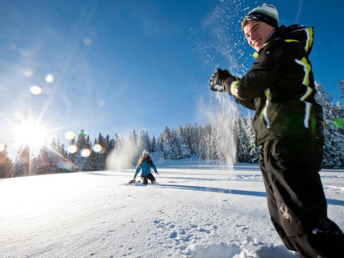 Paar macht eine Schneeballschlacht im Skigebiet Salzstiegl in der Steiermark. JUFA Hotels bietet erholsamen Familienurlaub und einen unvergesslichen Winterurlaub.