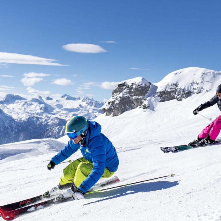 Sie sehen ein Paar beim Skifahren auf dem Loser im Winter. JUFA Hotels bietet erholsamen Familienurlaub und einen unvergesslichen Winterurlaub.