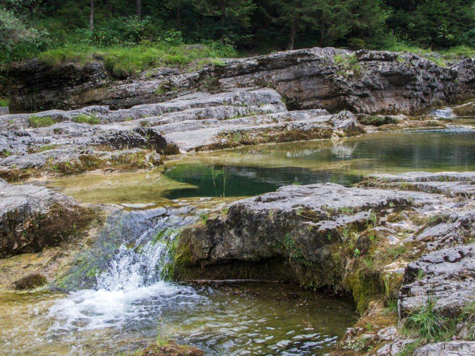 Idyllischer Badeplatz mit Felswannen und kühlem Wasser, ideal für heiße Sommertage.