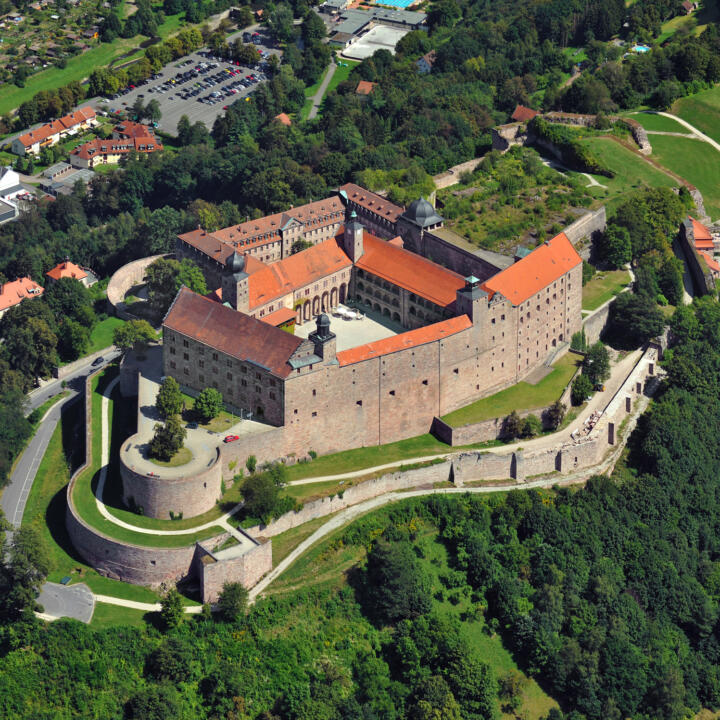 Sie sehen eine Luftaufnahme der Festung Plassenburg in Kulmbach. JUFA Hotels bietet kinderfreundlichen und erlebnisreichen Urlaub für die ganze Familie.