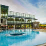 Sie sehen den Außenbereich der Therme Nova im Sommer, das große runde Pool lädt zum Schwimmen ein. JUFA Hotels bietet erholsamen Familienurlaub und einen unvergesslichen Winter- und Wanderurlaub.