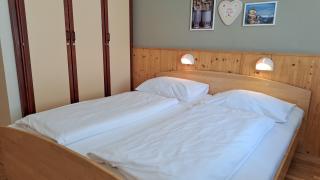 Sie sehen ein Bild vom Low Budget 2 Zimmer mit Doppelbett, Wanddeko und Kasten im JUFA Hotel Bad Aussee*** in der Steiermark.