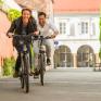Sie sehen einen Mann und eine Frau beim Radfahren in der Alstadt von Bad Radkersburg, ganz in der Nähe vom JUFA Hotel Bad Radkersburg.