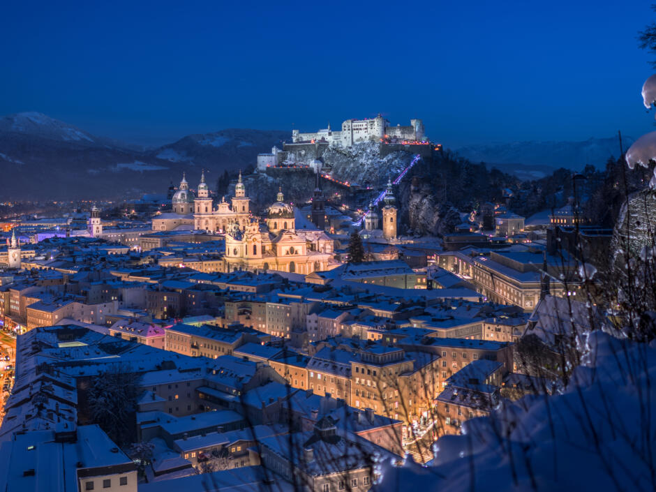 Sie sehen den Blick vom Mönchsberg auf die winterliche Festung mit Abendstimmung.