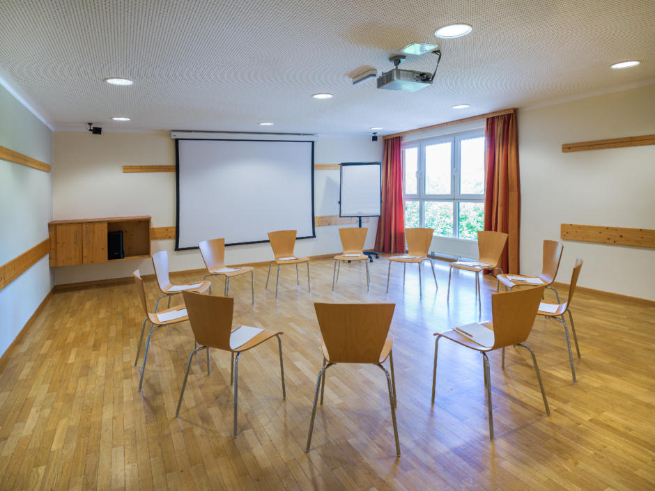 Sie sehen den großzügigen Seminarraum mit FlpChart und Leinwand im JUFA Hotel Bad Aussee***. Der Ort für erfolgreiche und kreative Seminare in abwechslungsreichen Regionen.