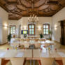 Sie sehen einen Seminarraum mit Tischen in Frontalansicht im JUFA Hotel Schloss Röthelstein/Admont***. Der Ort für märchenhafte Hochzeiten und erfolgreiche und kreative Seminare.