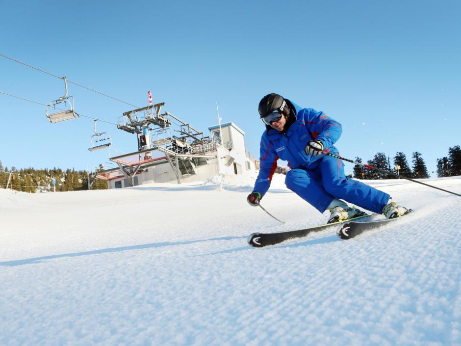 Skifahrer fährt auf einer perfekt präparierten Piste im Skigebiet Hochkar im Mostviertel. JUFA Hotels bietet erholsamen Familienurlaub und einen unvergesslichen Winterurlaub.