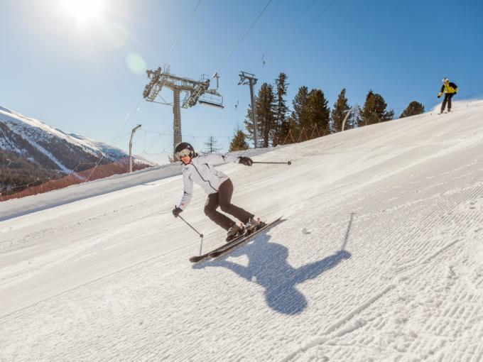Eine Skifahrerin fährt gekonnt die bestens präparierte Piste im Skigebiet Turracher Höhe in Kärnten hinunter. JUFA Hotels bietet erholsamen Familienurlaub und einen unvergesslichen Winterurlaub.