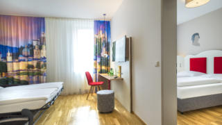 Sie sehen Betten in einer Suite4 im JUFA Hotel Salzburg City. Der Ort für erholsamen Familienurlaub und einen unvergesslichen Winter- und Wanderurlaub.