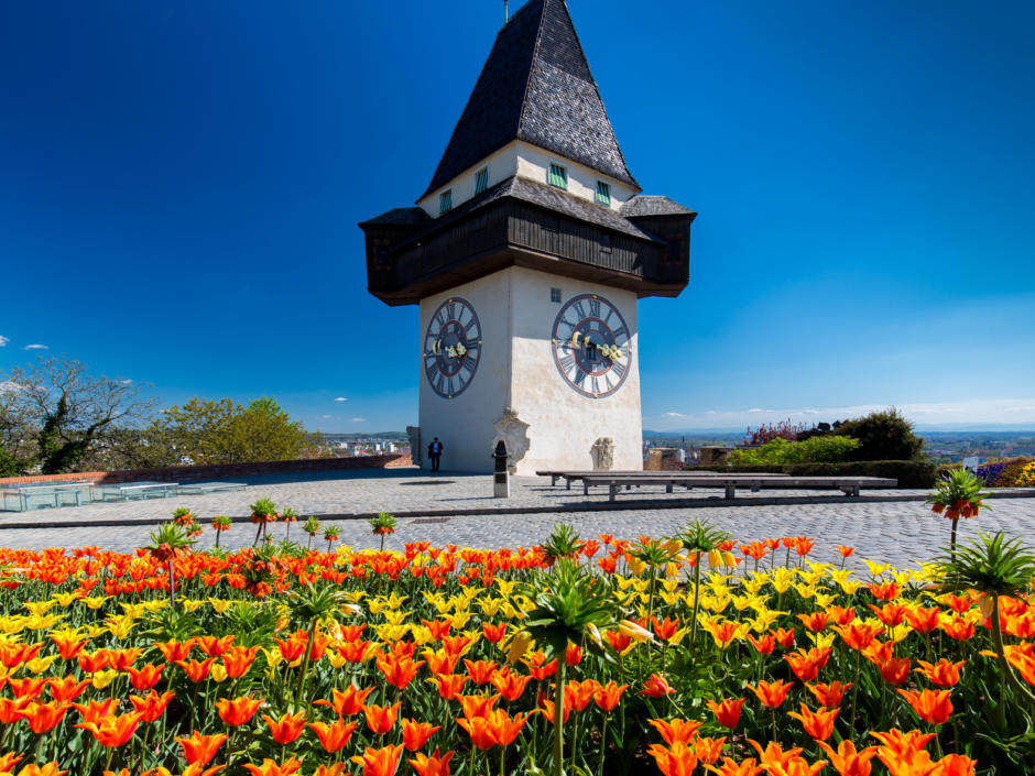 Sie sehen den Uhrturm in Graz im Frühling. JUFA Hotels bietet erholsamen Familienurlaub und einen unvergesslichen Winterurlaub