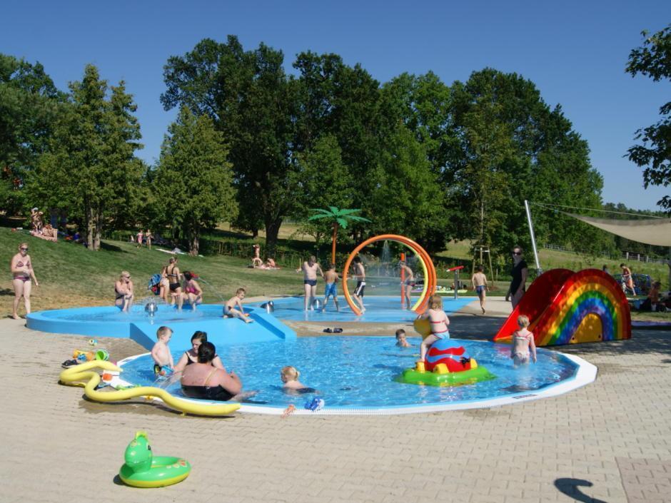 Menschen baden im Kinderplantschbecken im Waldbad Neutal. JUFA Hotels bietet Ihnen den Ort für erlebnisreichen Natururlaub für die ganze Familie.