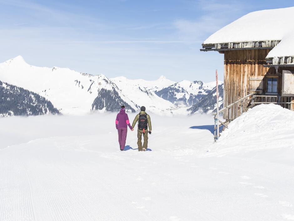 Sie sehen ein Paar beim Winterwandern im Biosphärenpark Großes Walsertal in Vorarlberg