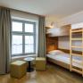 Sie sehen ein Etagenbett für zwei Personen mit Sitzecke und großem Fenster im Appartement im JUFA Hotel Schilcherland*** in der Steiermark.
