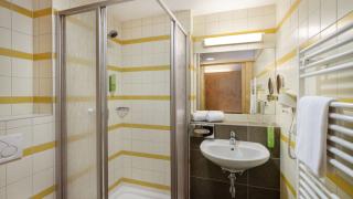 Sie sehen ein Badezimmer im Doppelzimmer plus mit Dusche, WC und Waschbecken im JUFA Hotel Schilcherland*** in der Steiermark.